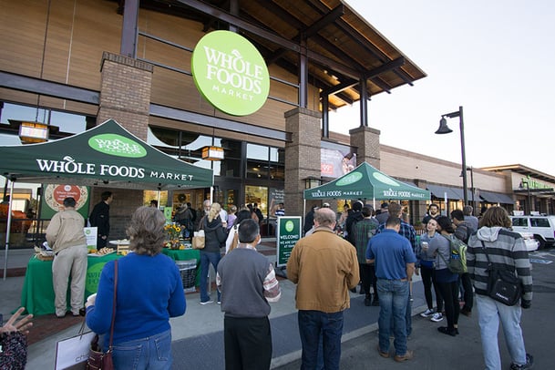 Customers standing around outside at Whole Foods Market grand opening. 