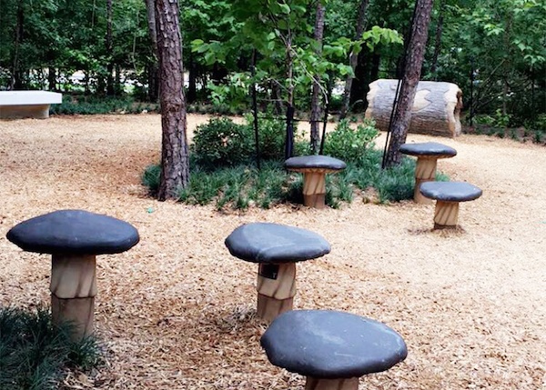 Several stools in the playground made to look like mushrooms. 