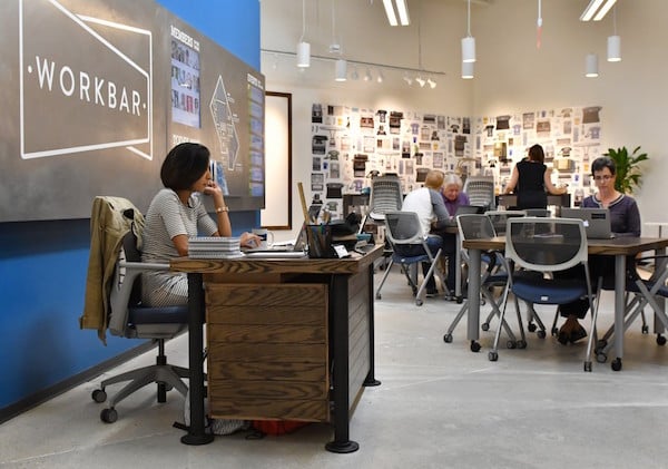 Customers using laptops in the Workbar area. 