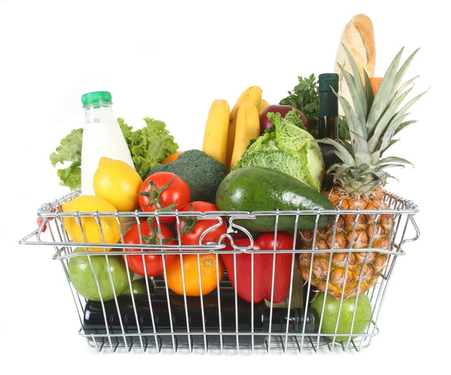 Shopping basket containing milk, break, wine and various fruits and vegetables.