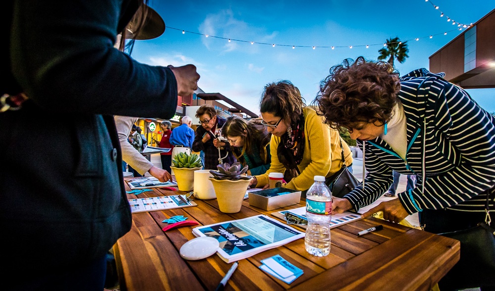 people filling out forms on a table outside