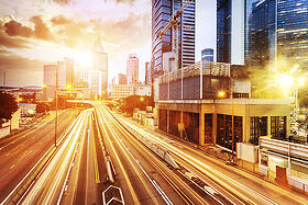 Highway at sunset with skyscrapers along the road