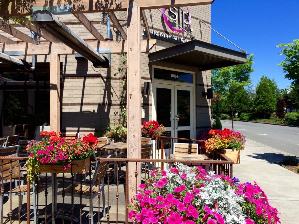 Sip bar at Grand Ride Plaza exterior shot of outdoor patio with colorful flowers