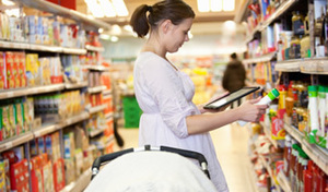 Woman shopping in grocery store looking at mobile device