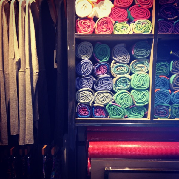 Rolled up shirts on display inside retail location with rack of shirts on the side