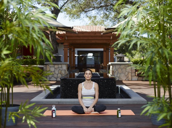Woman doing yoga in a serene setting with bamboo trees within a shopping plaza