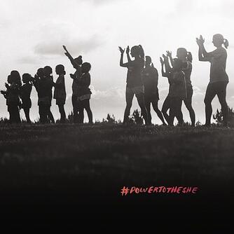 Black and white image of women on a hill clapping, reading #powertotheshe