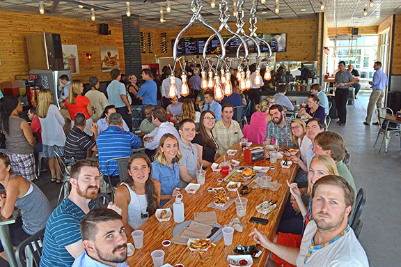 Many people eating at a long wooden table
