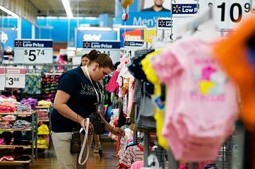 Woman working and putting price stickers on clothing in Walmart store