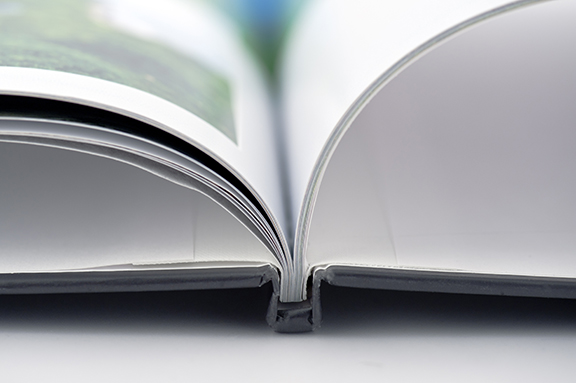 Up close image of a book spine opened to the middle with pages open