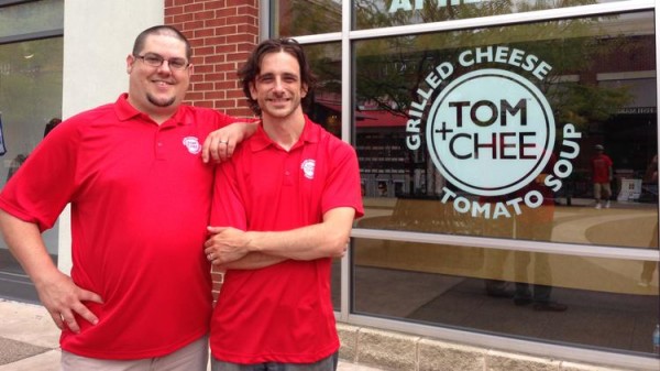 two men in red polos outside of Tom+Chee store front