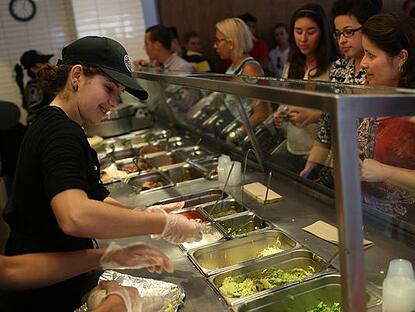 Chipotle Mexican grill assembly line with employees working on burrito orders