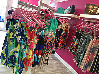 Rack of bright patterned clothing in Pink Nickel store