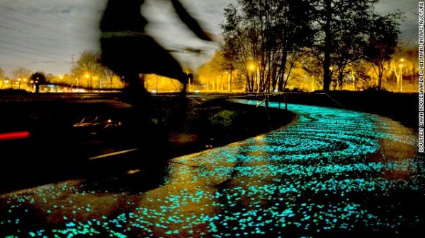 illuminated bike path at night with blurred biker steaking by