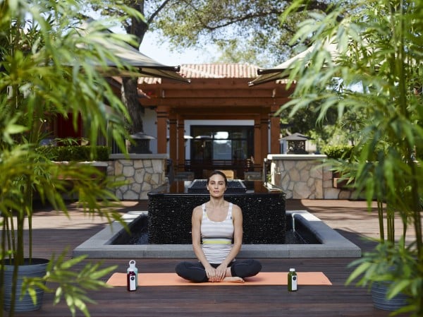 woman doing yoga in a serene setting with bamboo trees within a shopping plaza