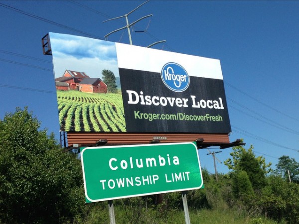 Billboard in Columbia for Kroger stores with "Discover Local" as the headline, along with the URL to kroger.com / discover fresh. Picture also includes sign for Columbia township limit