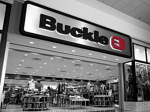 black and white image of a Buckle storefront within a mall