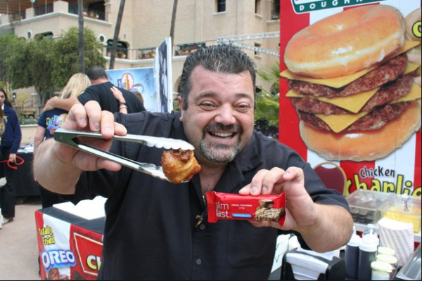 Chicken Charlie showing off a fried slim fast bar at a festival