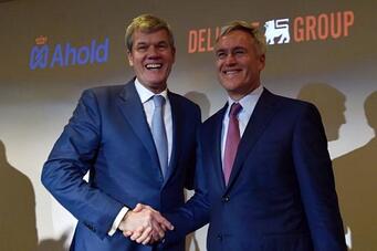 Handshake between Ahold and Delhaize grocery store owners