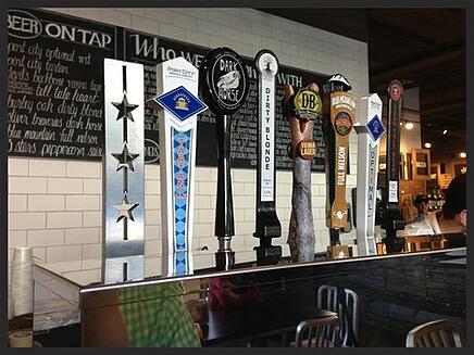 row of beer taps at a bar