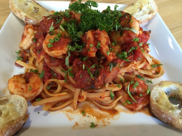 pasta dish of linguini with shrimp and marinara sauce with fresh parsley and garlic bread
