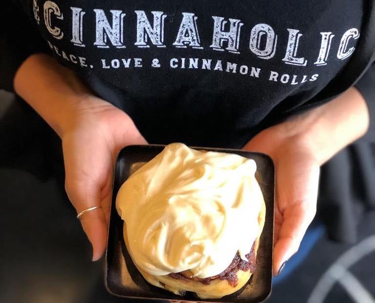 Woman Holding Cinnaholic cinnamon bun