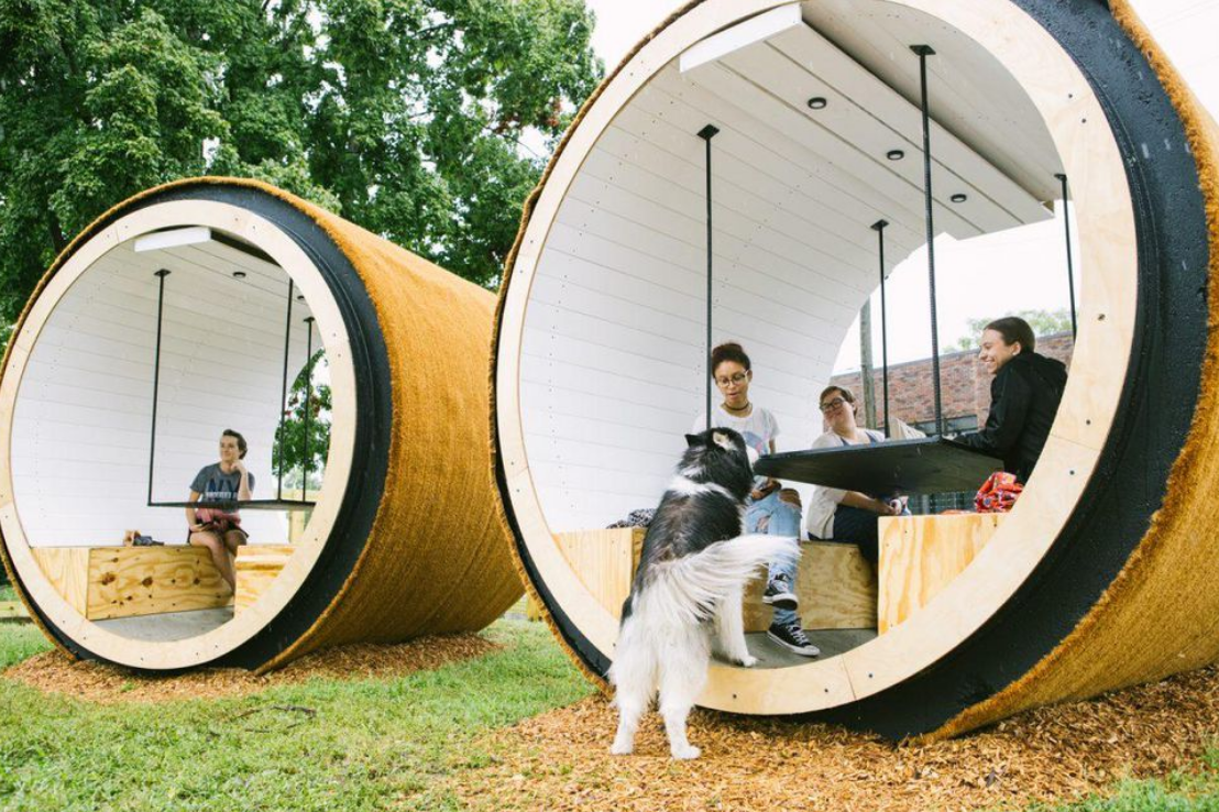 seating area in Bark Park inside of large cylinders that look like barrels of hay. 