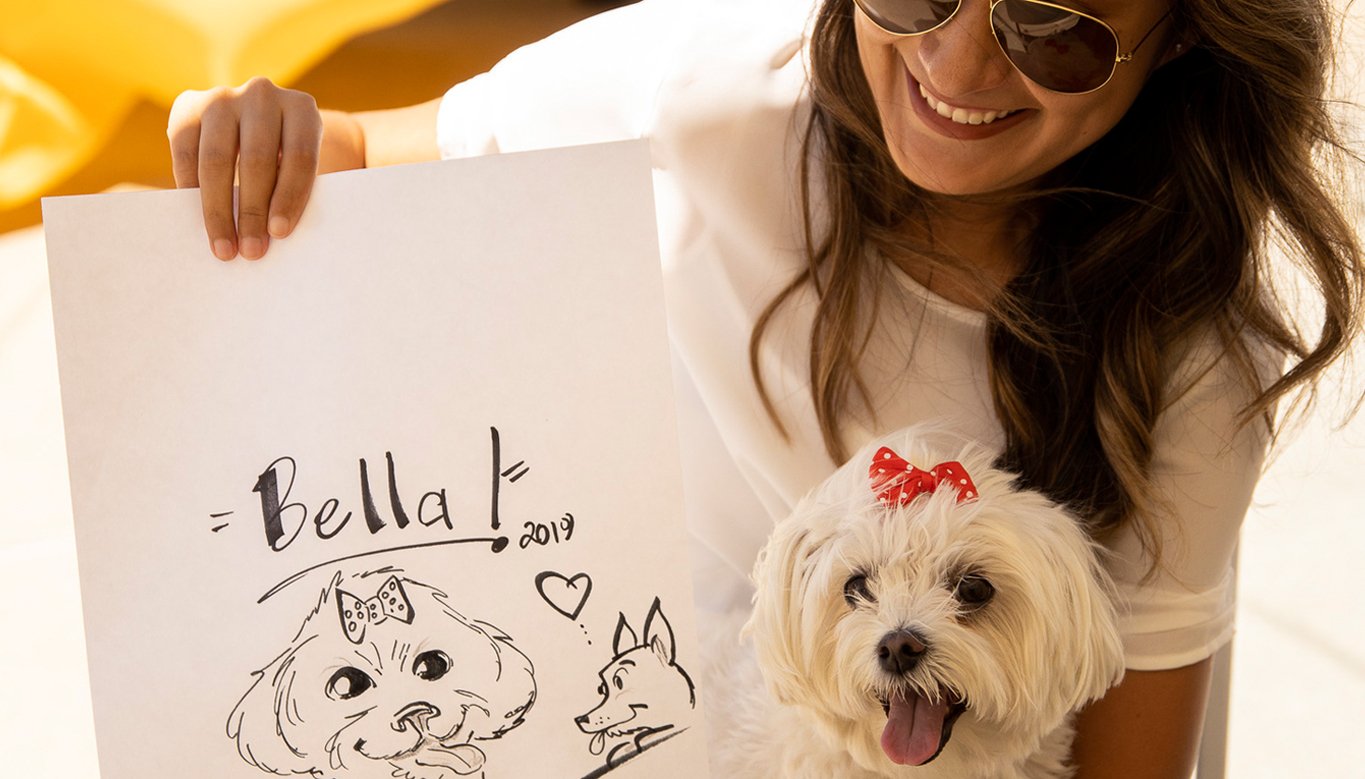 Dog owner posing with dog and drawing of her dog