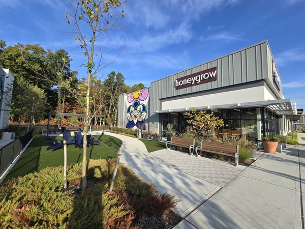 HoneyGrow storefront with outdoor sitting area and greenery
