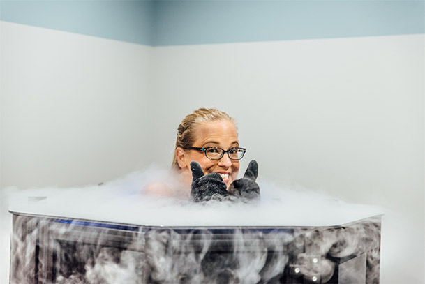 Woman, and writer of story, smiling for camera while inside a cryogenic chamber.