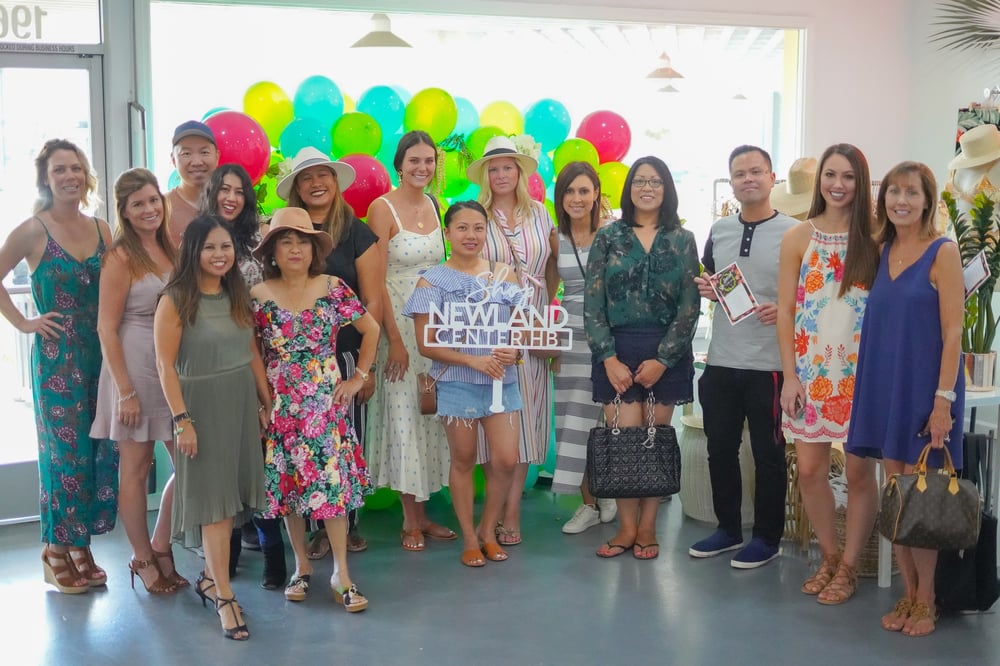 Influencer group posing with signage and balloons at Newland Center