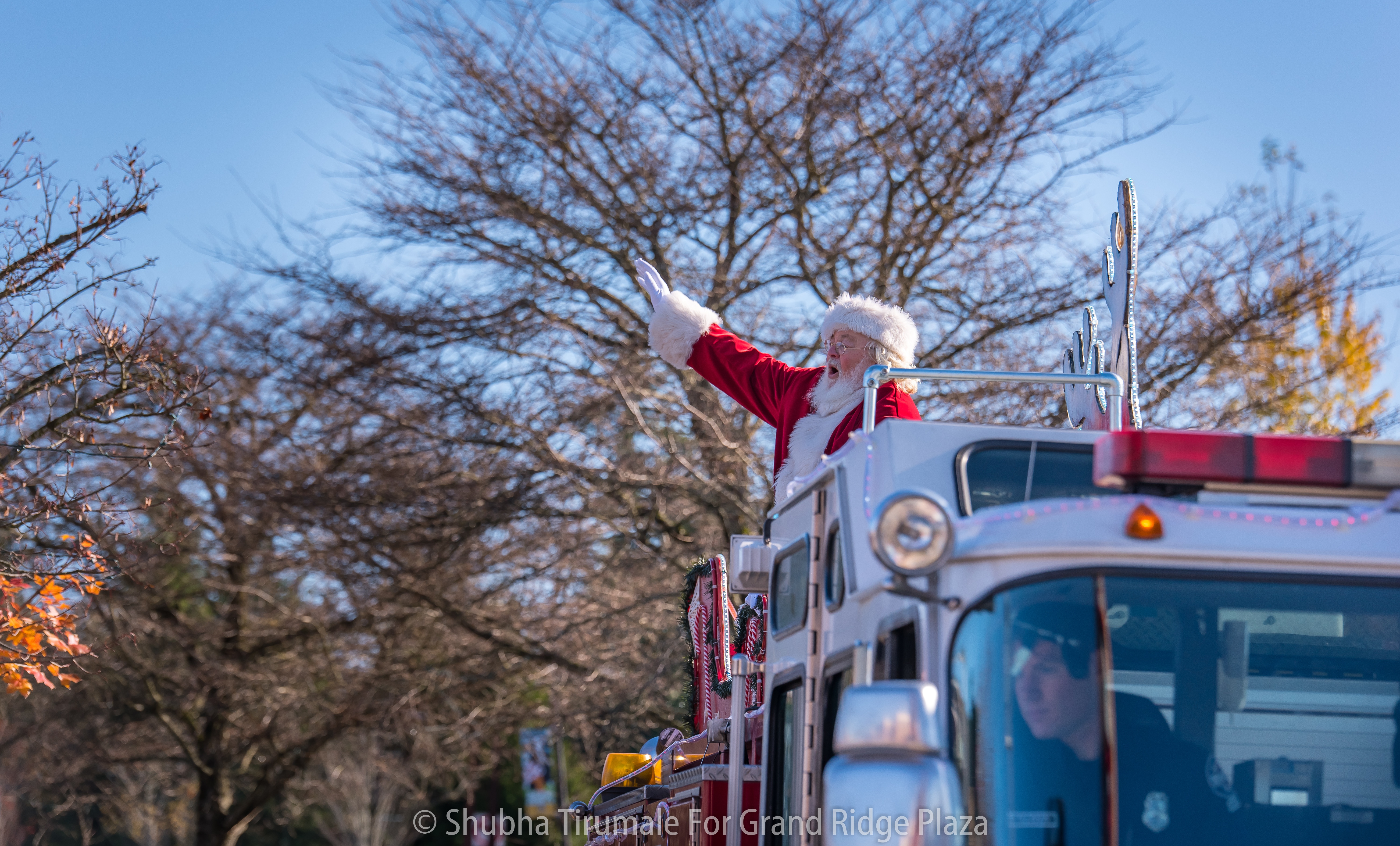 Santa waving from the top of a firetruck