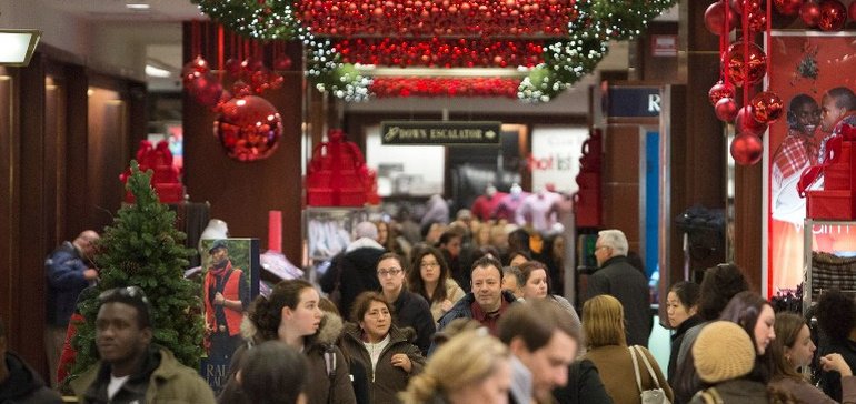 Black Friday shoppers inside a mall with Christmas decorations.