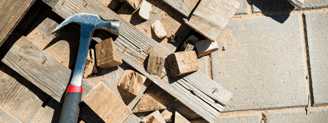 Hammer lying down on scrap wood. 