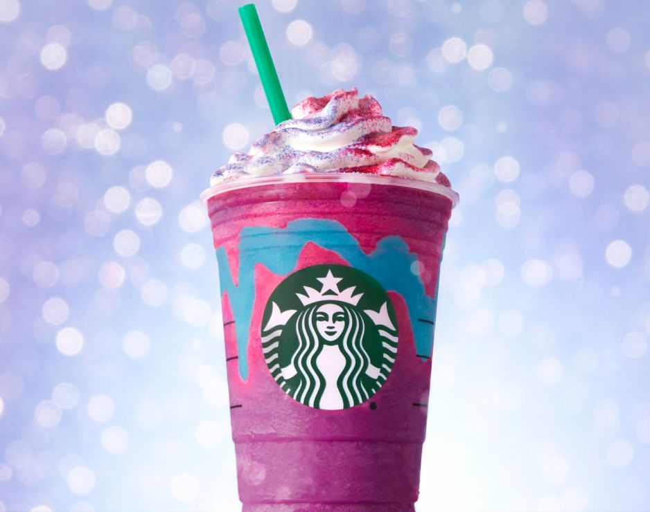 Starbucks purple and pink Unicorn Frappucino with whipped cream and purple and pink sprinkles on top.