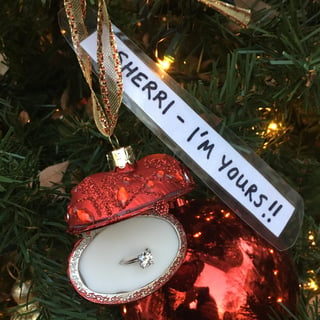 The engagement ring inside an ornament on the tree. A note above it reads, "Sherri, I'm yours!!" 
