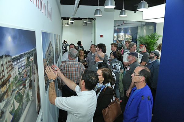 A crowd of people looking at architecture renderings at the event. 