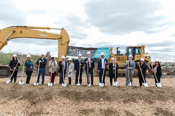 Regency employees holding shovels and wearing hardhats at a groundbreaking ceremony.