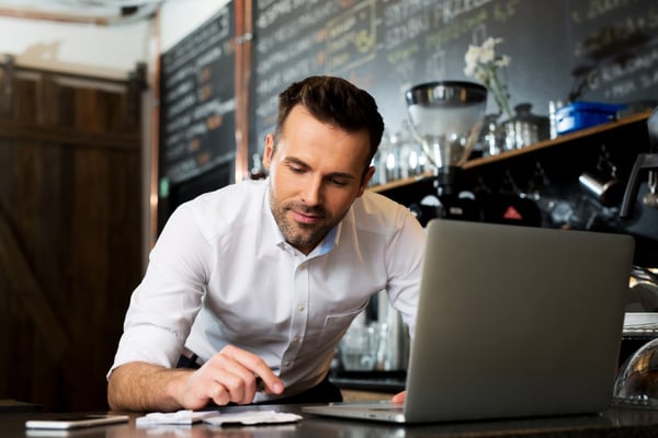 Man using a laptop in a coffeehouse. 