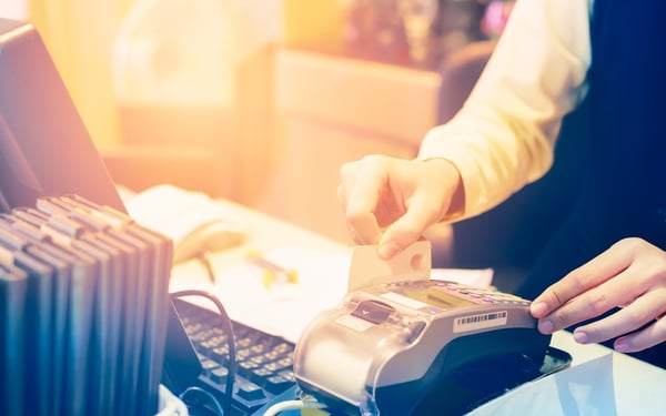 Store employee swiping a credit card at the register. 