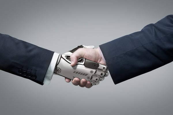 A close-up of a robot hand shaking a human hand. 