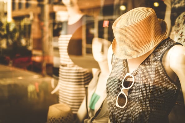 Women's clothing and hat on a mannequin in a store window. 