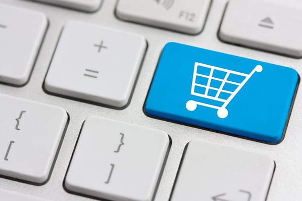 Close-up of a grey keyboard with a blue key that has a shopping cart on it. 