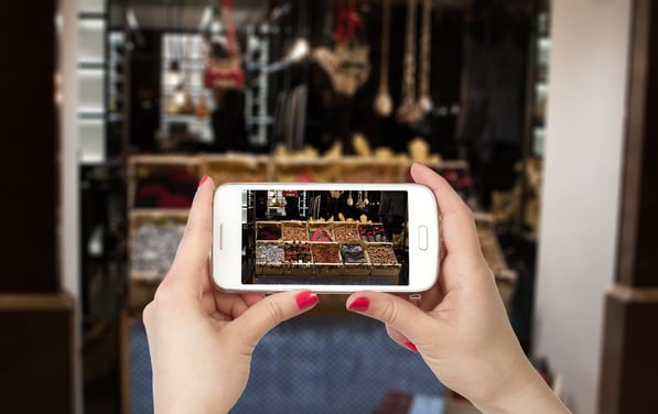 First-person view of hands holding an iPhone that's displaying store items. 