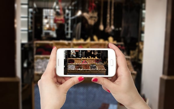 Regency May Blog8.jpg First-person view of hands holding a smartphone photographing store items and displays