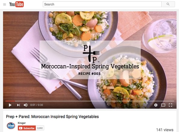 A YouTube video from Kroger showing an overhead view of two plates of food and a drink on a wooden table. 