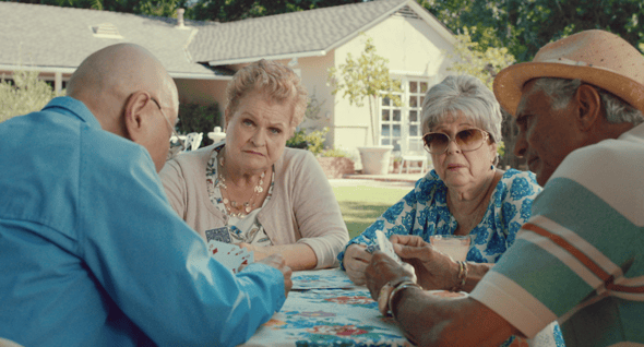 Image from a Mcdonald's commercial of two grandmas and two grandpas playing cards in a yard. 