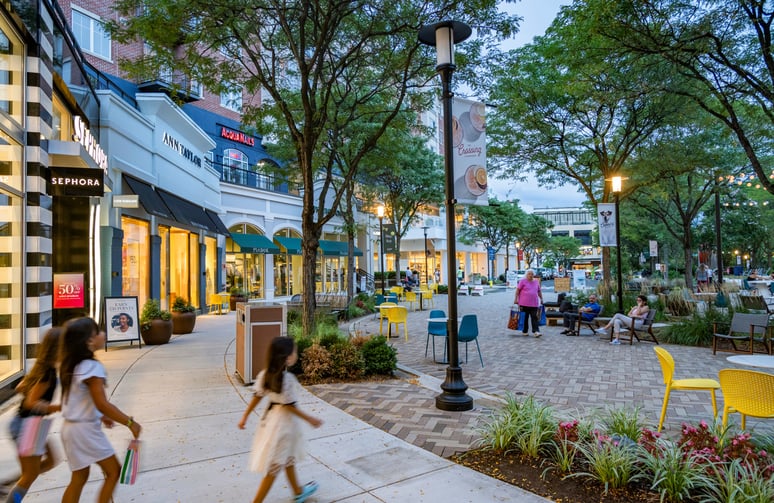 Shoppers stroll through The Loop at The Crossing Clarendon, surrounded by storefronts.