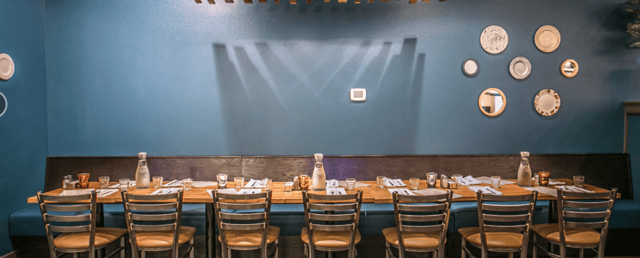 long table inside of restaurant with table setting