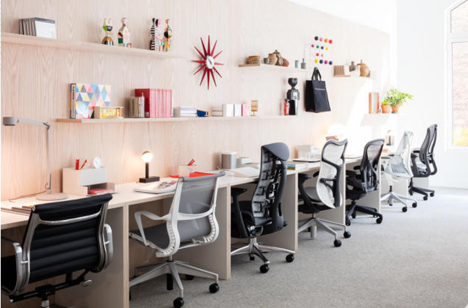 Various workstations, office chairs and desk items inside the Herman Miller store. 